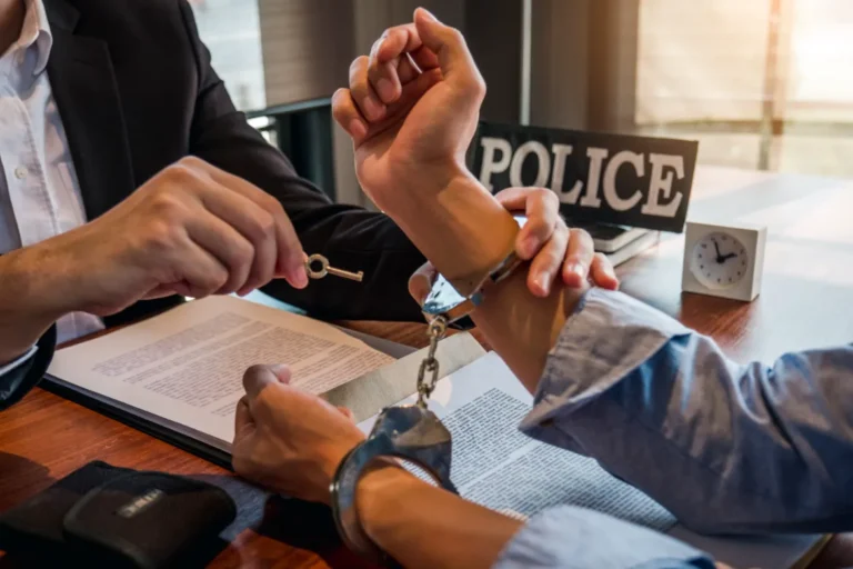 A man ready to open with a key on the handcuff that man has.